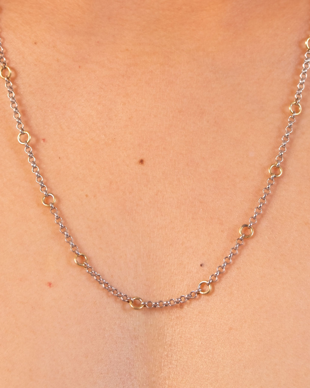 Silver Tiny Linky Chain Circle necklace by MAISON MEGH with small, interconnected circular links on a plain background.