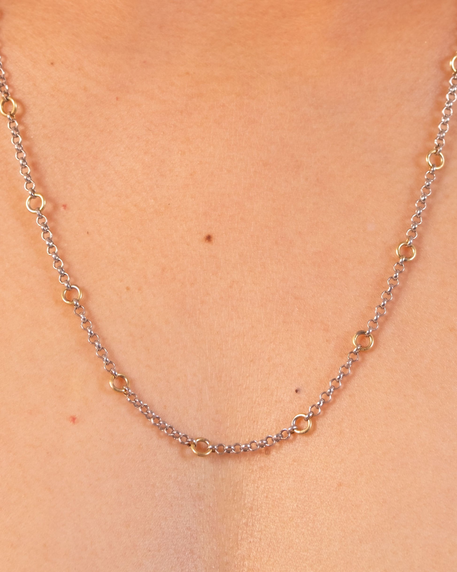 Silver Tiny Linky Chain Circle necklace by MAISON MEGH with small, interconnected circular links on a plain background.
